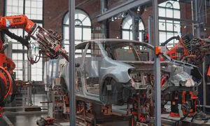 picture of robots working on a car inside a factory