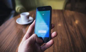 hand holding a smartphone with twitter login screen visible