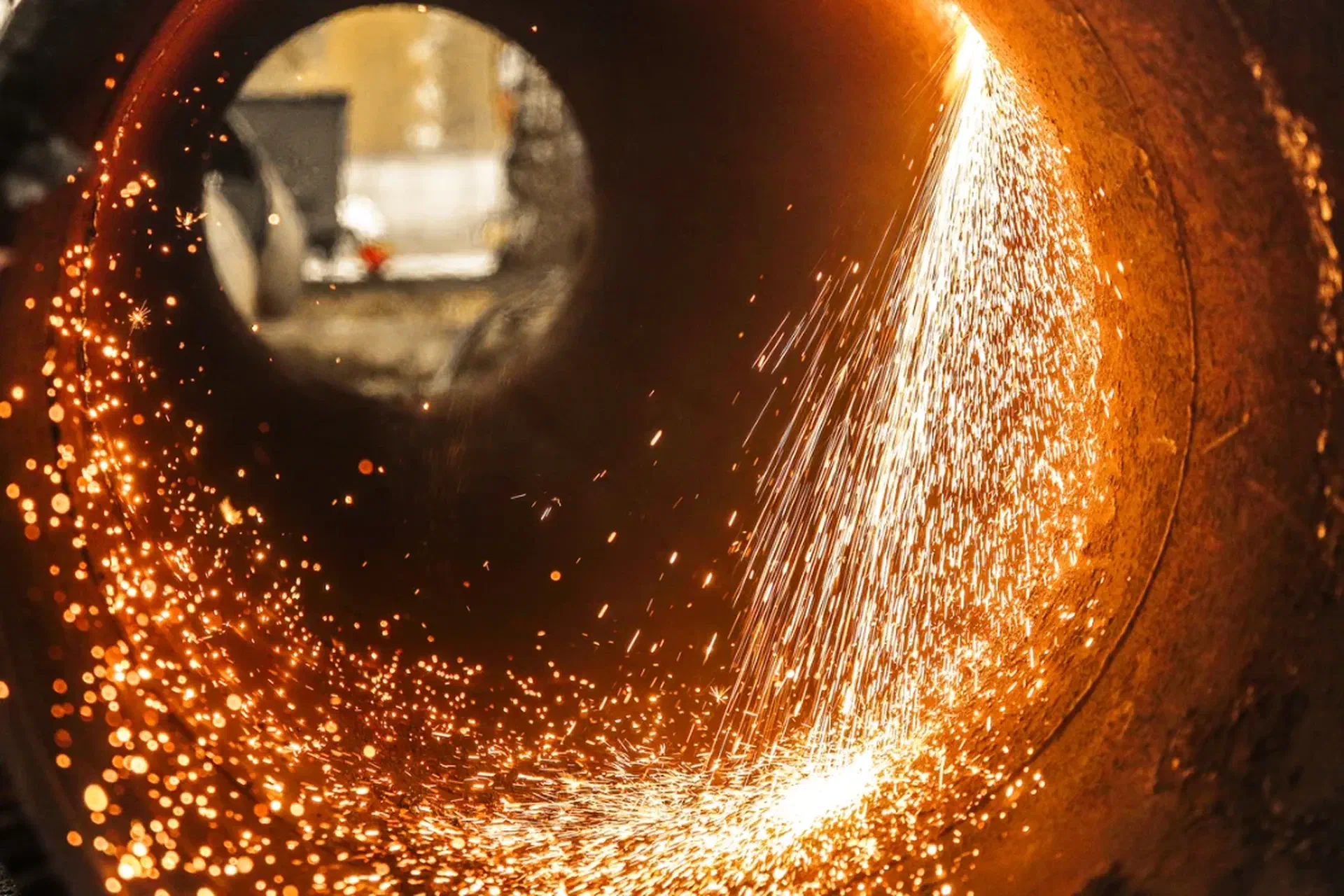 Inside a steel pipe as it is cut, sparks flying