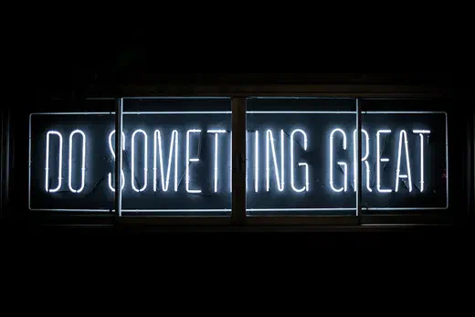 Neon sign reading 'Do something great'.