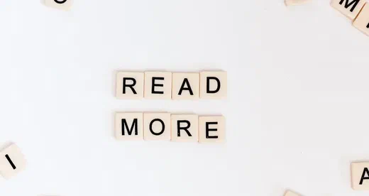 Scrabble tiles spelling 'Read More'.