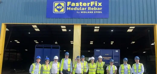 A group of people in hard hats and hi-vis vests outside the Midland Steel FasterFix Modular Rebar factory.