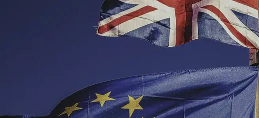 The Union Jack and European Union flags flying against a blue sky.
