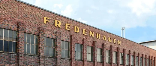 The Fredenhagen building facade with large brick pillars and rooftop lettering.