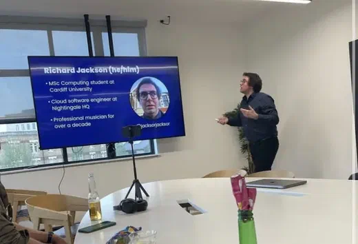Richard Jackson presenting beside a screen showing his speaker slide at Umbraco London