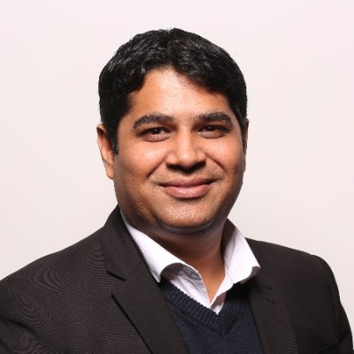 Gourav Tandon, India Country Head at Source Code Control, smiling in a dark suit over a navy jumper.