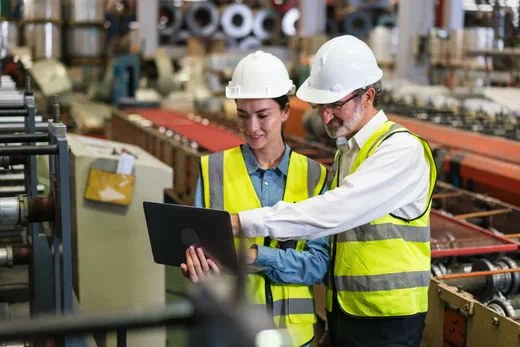 Employees looking at screen in industrial setting