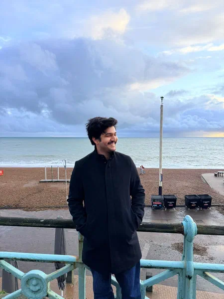 A photo of Muhammad Saad standing by the seafront in Brighton